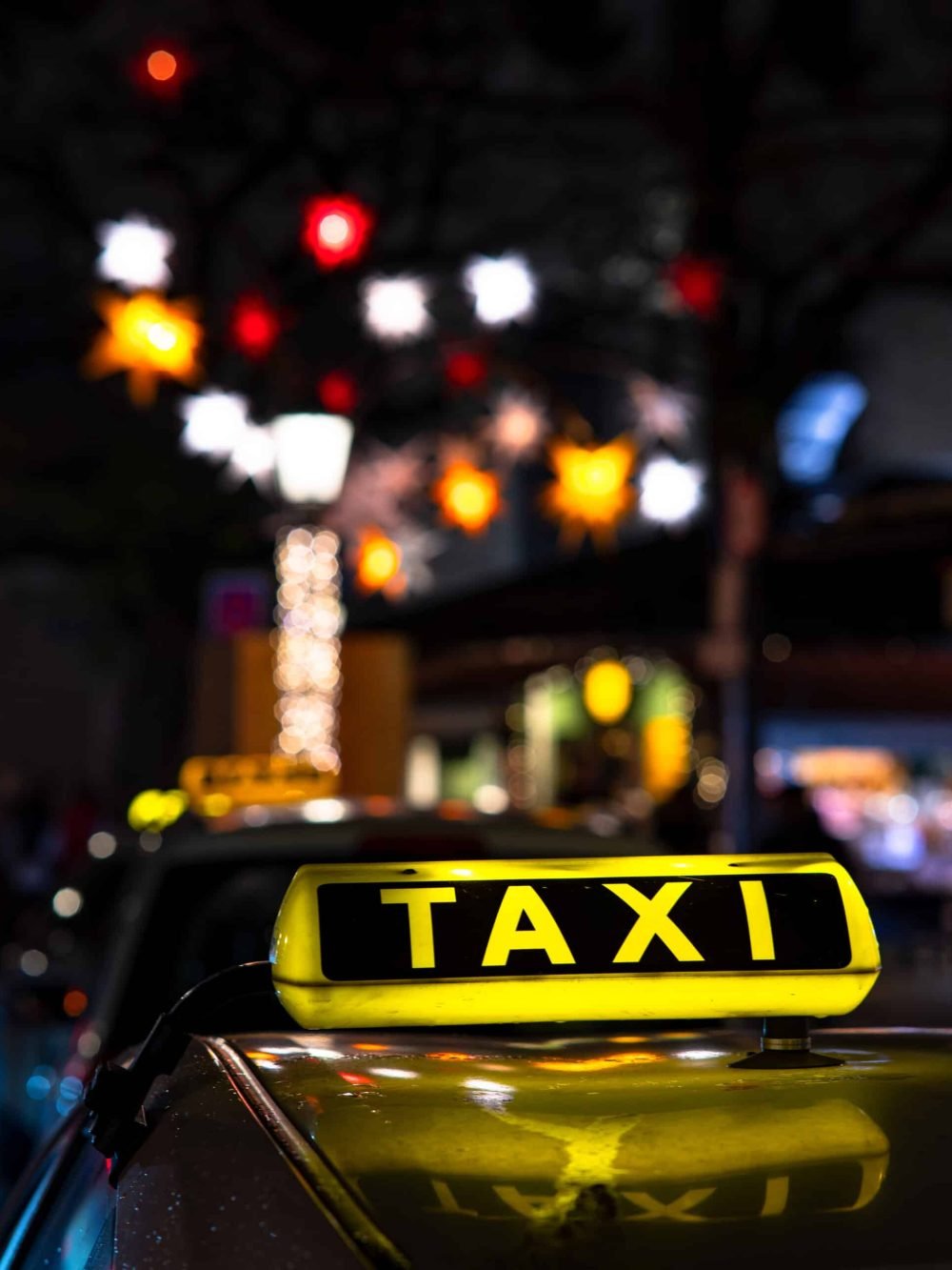 a shot of german taxi signs, illuminated by night with blurred city lights in background